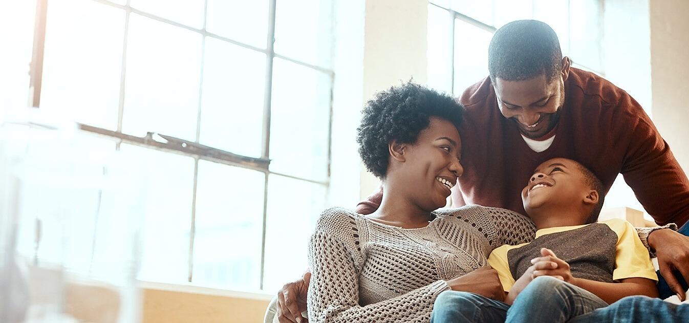 Happy couple with child sitting by window